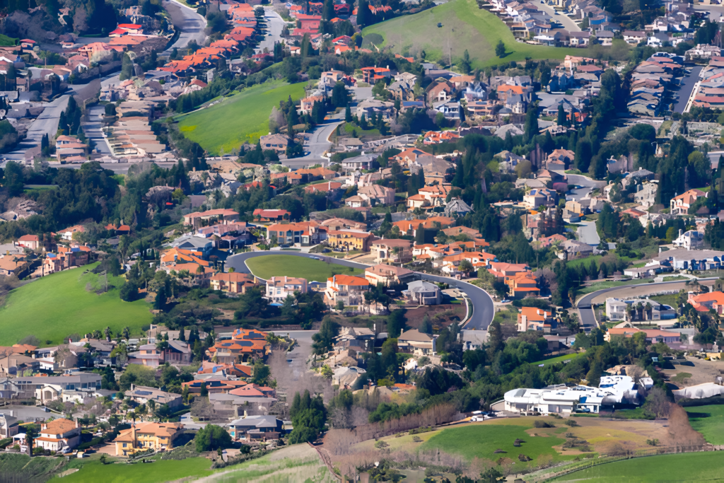 Fremont, CA real estate neighborhood with houses, roads, and green spaces seen from above.